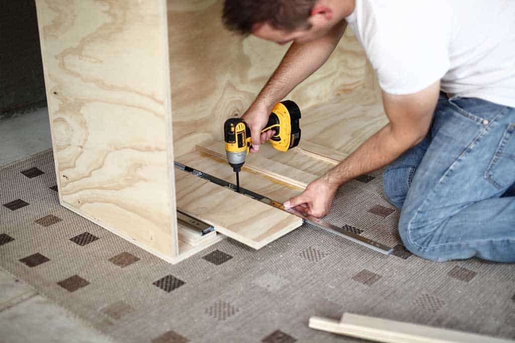 attaching drawer sliders in the DIY closet organizer