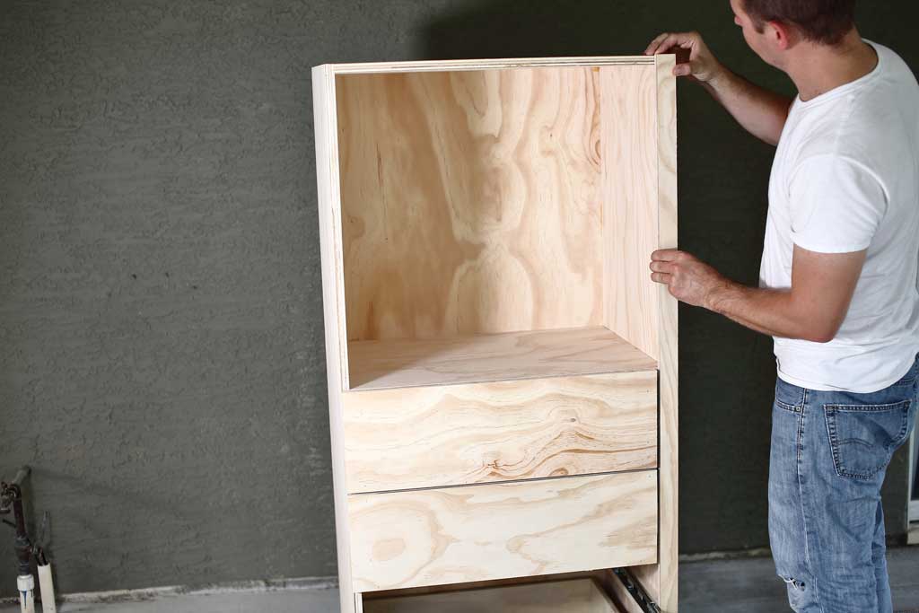 attaching plywood board to the DIY closet organizer