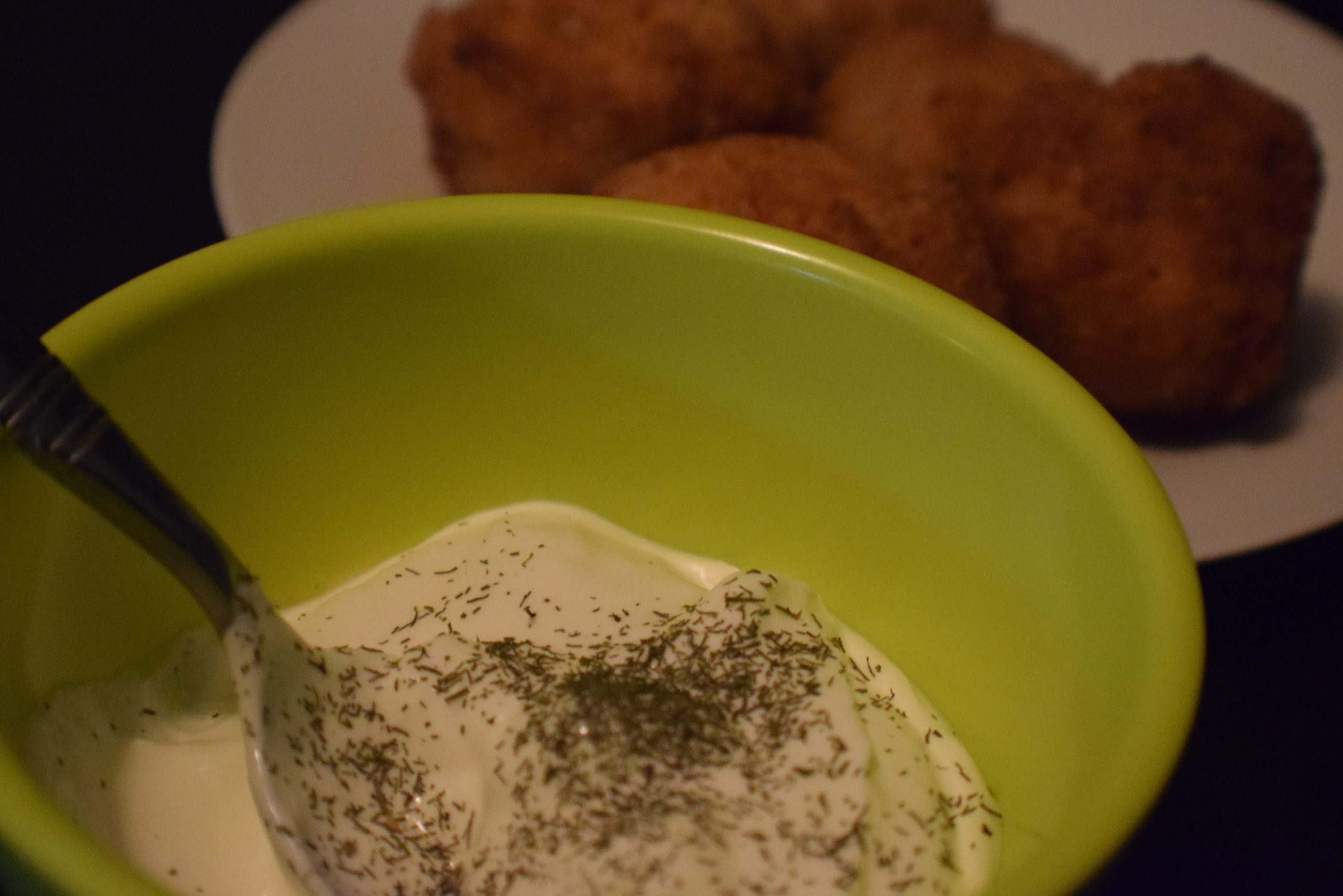 green bowl filled with sour cream and dill 