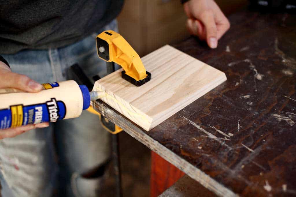 applying wood glue to the shelf board