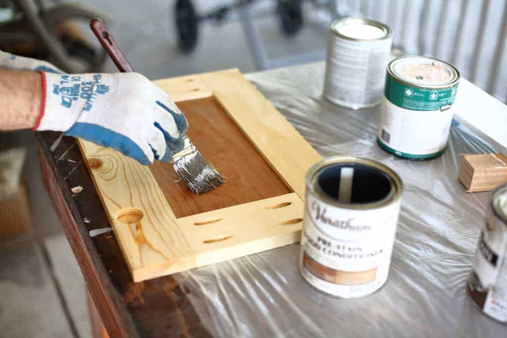 applying pre-stain on cabinet door