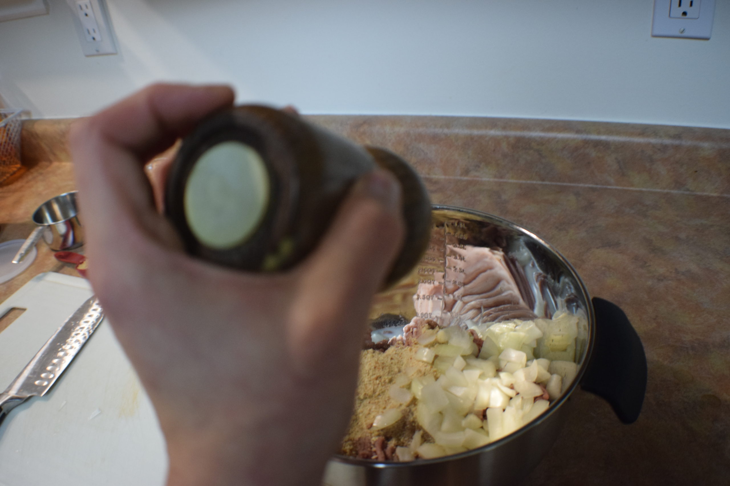 hand shaking salt into mix of ingredients in bowl