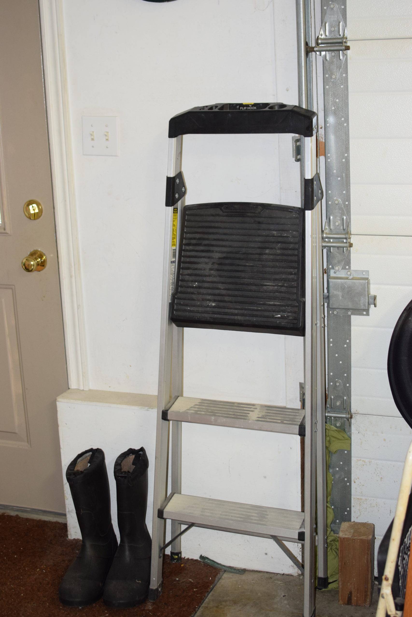 Step up ladder behind black working boots