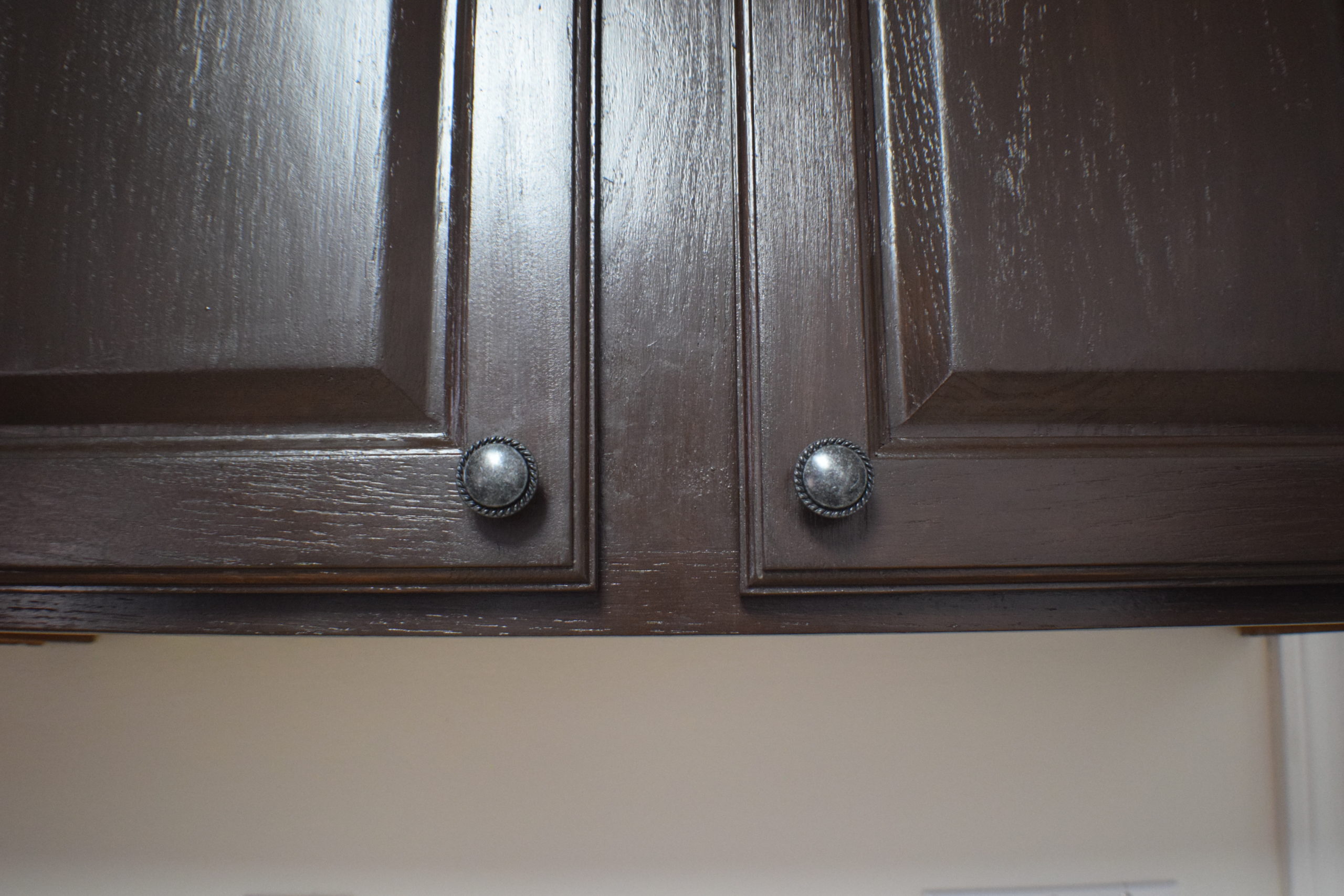 dark stained cabinet doors with new handles