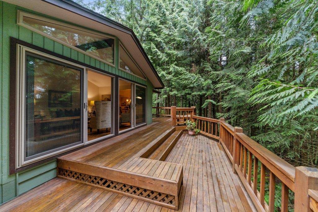 wooden deck on back of cabin in the woods