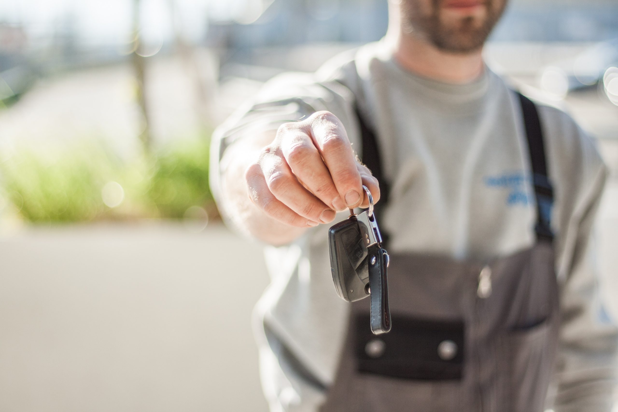 mechanic holding keys IN front of him outside