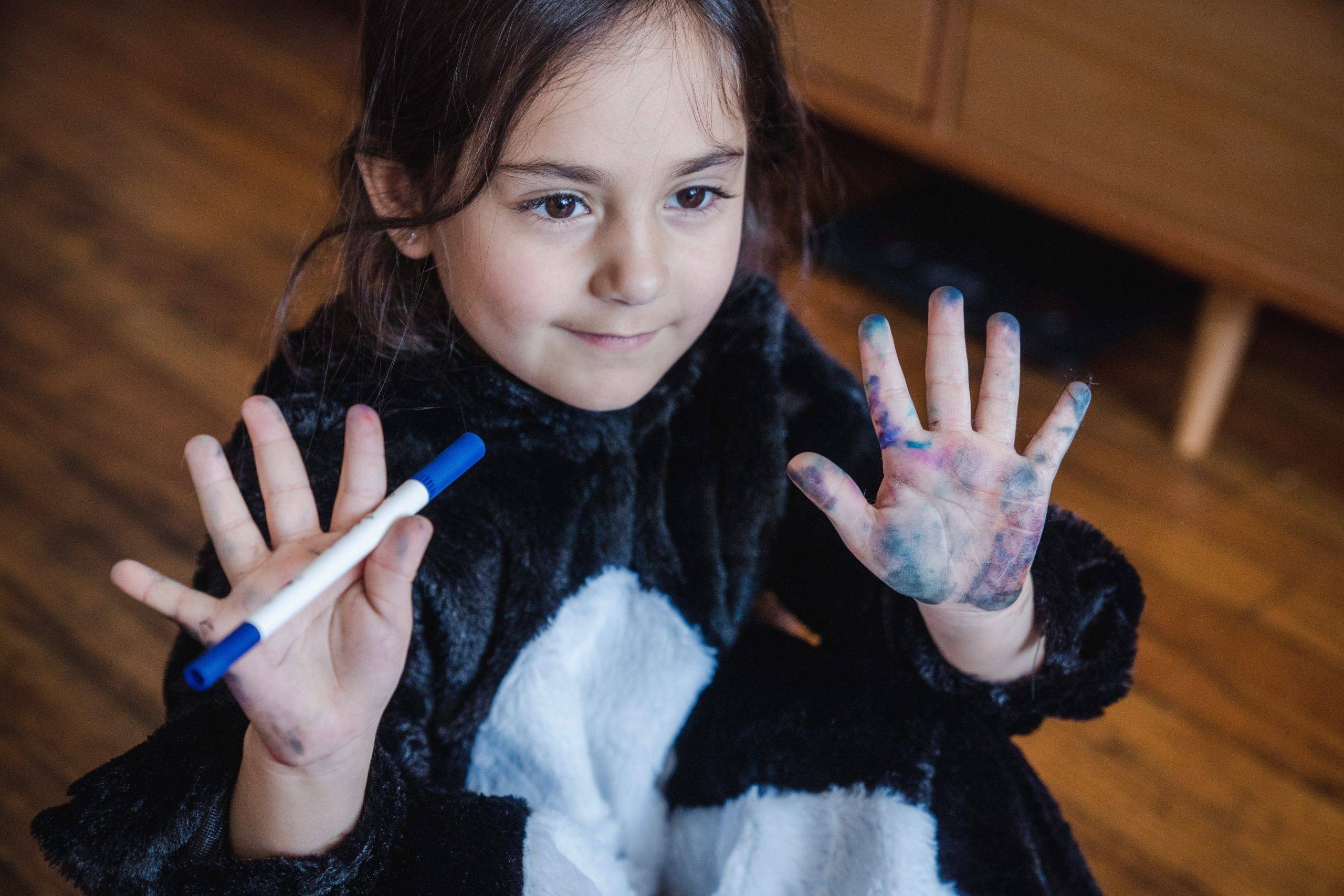 Child with permanent marker on her hands