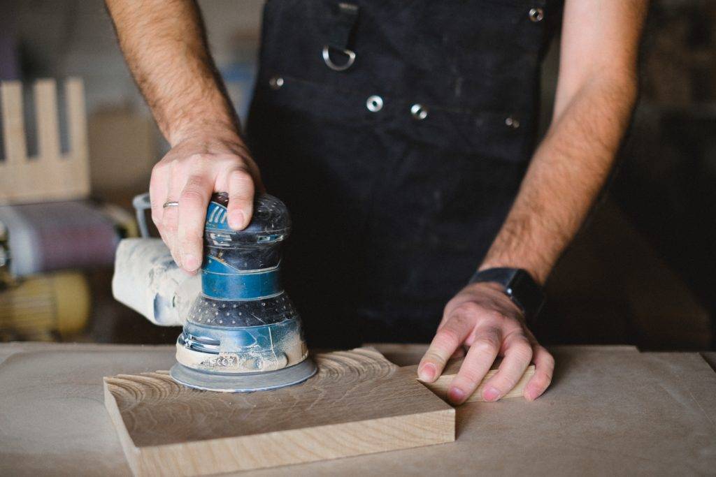 man using orbital sander