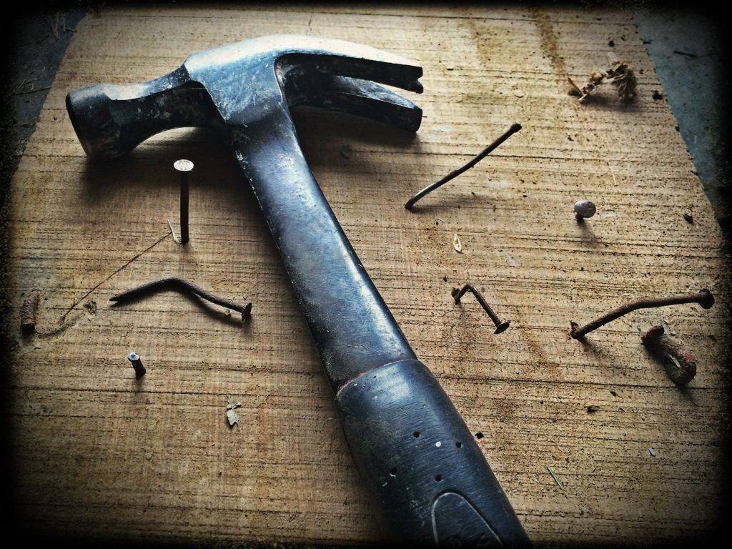 hammer with nails on a board