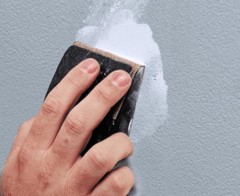 sanding joint compound applied to drywall hole