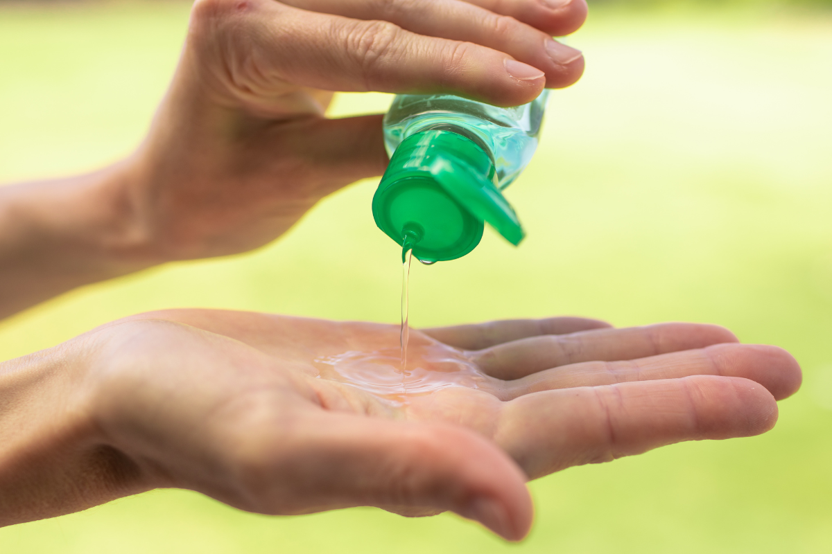 bare hands pouring out hand sanitizer