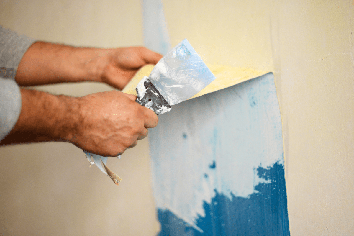 close of up hands removing wallpaper