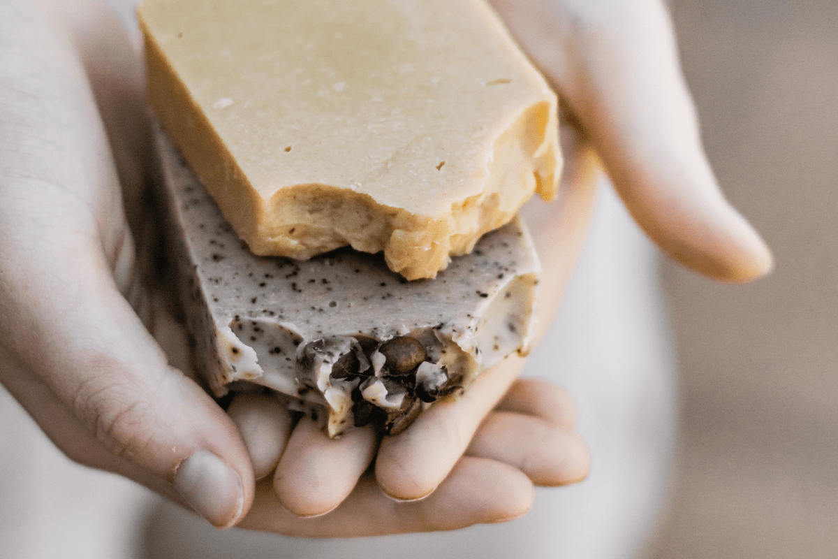 hands holding bars of artisan soap cold press close up