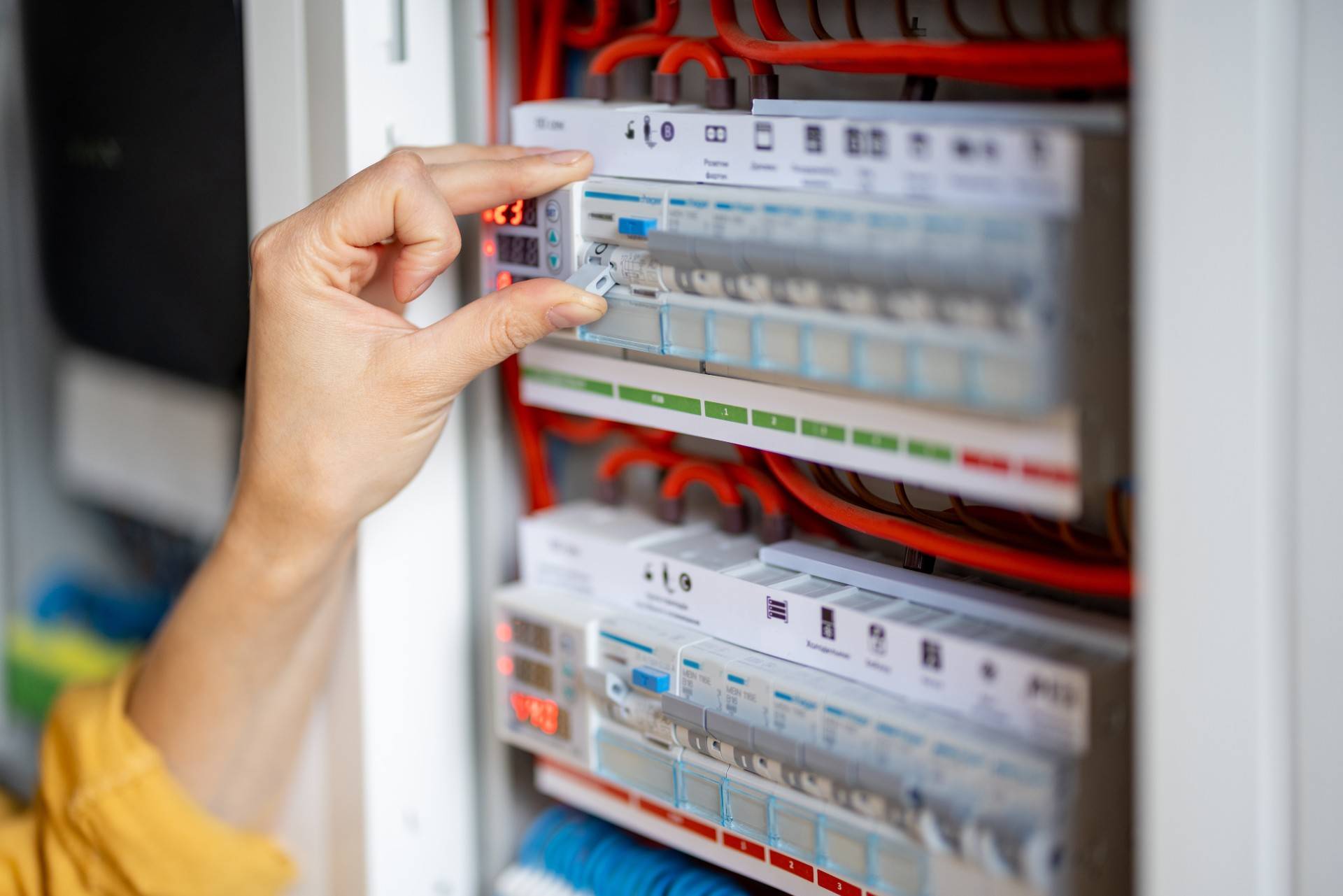 woman's hand reaching towards circuit breaker