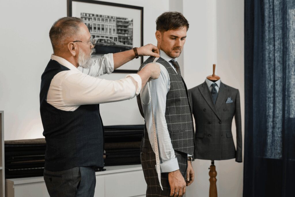 man being measured by a tailor