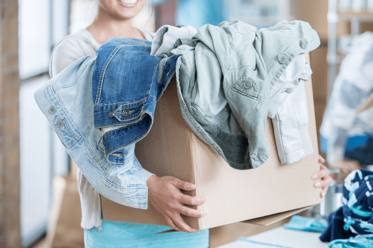 woman carrying box of clothes