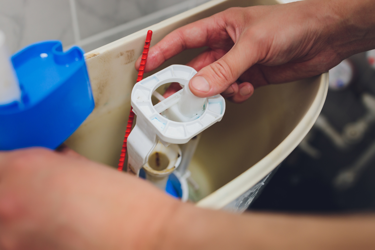 man fixing a toilet up close