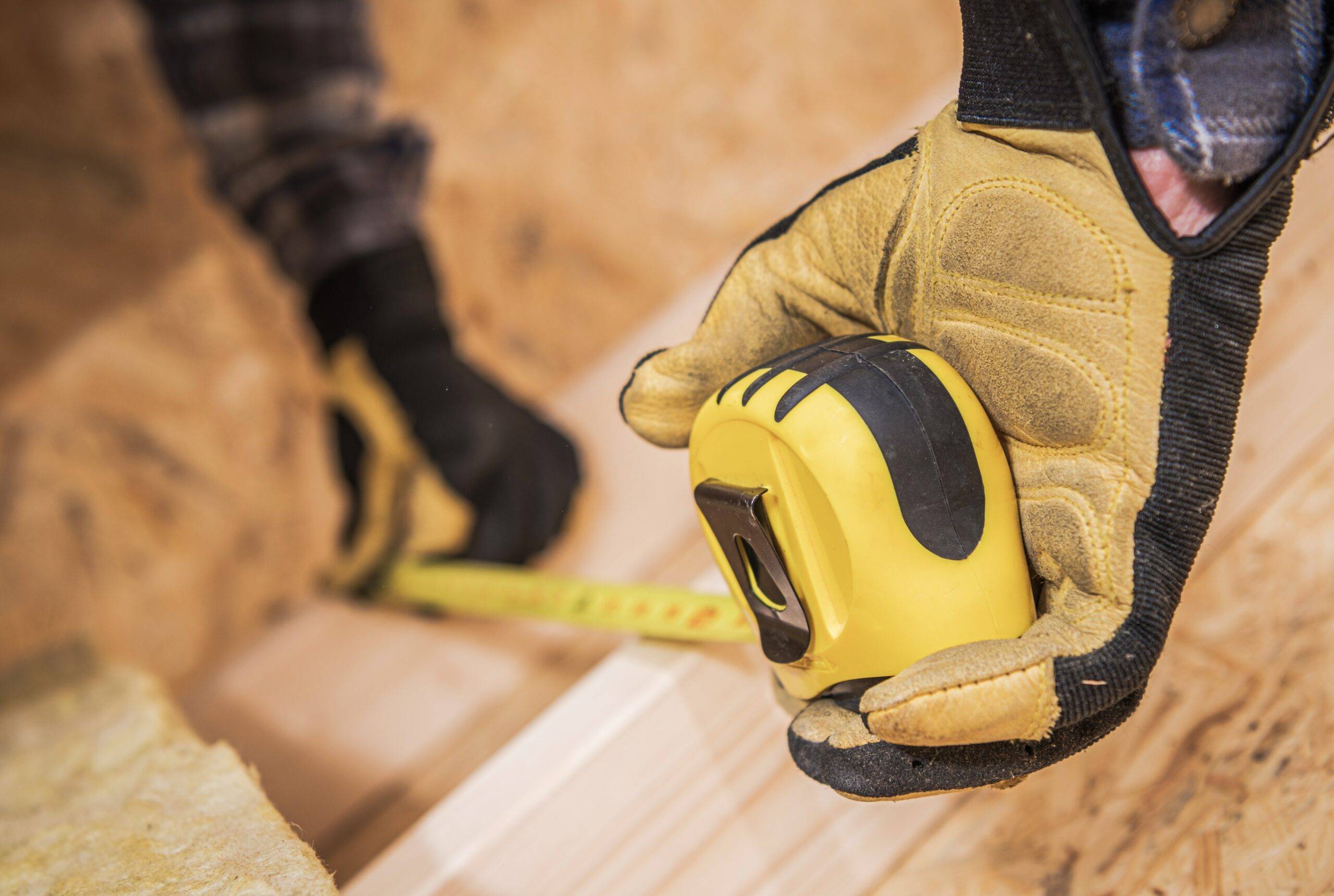 Worker with Measuring Tape Closeup. Dimensions Check. Construction Industry.