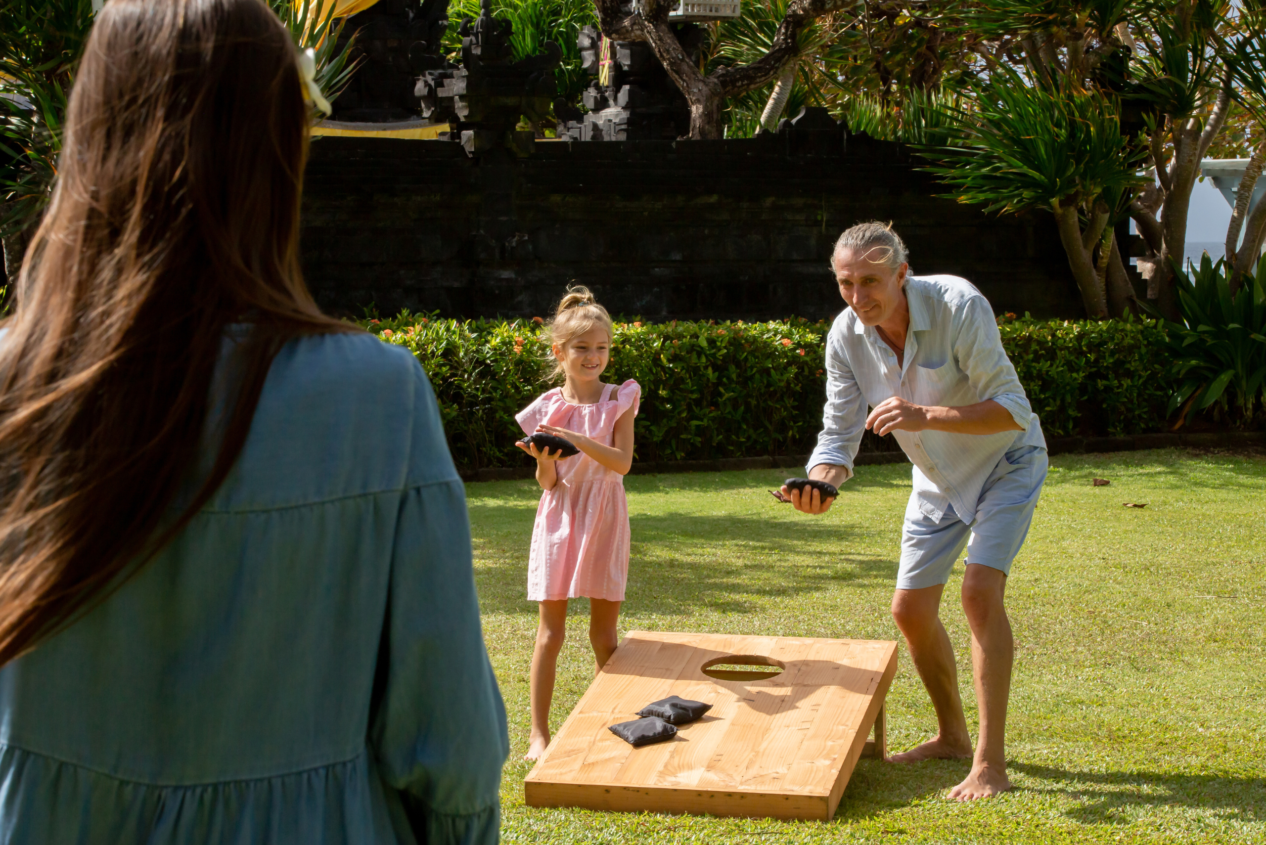 Family playing cornhole.