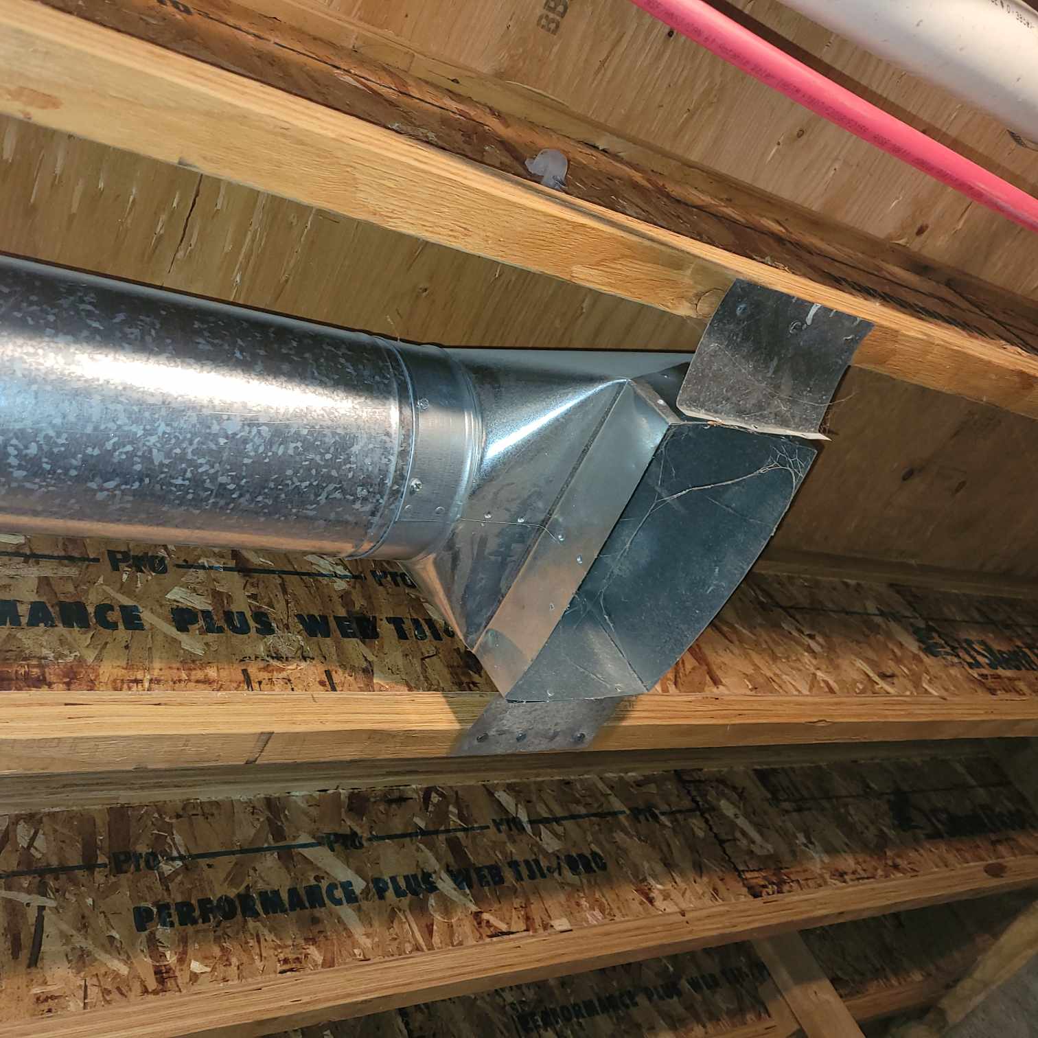 Air vent mounted on basement ceiling between the beams.