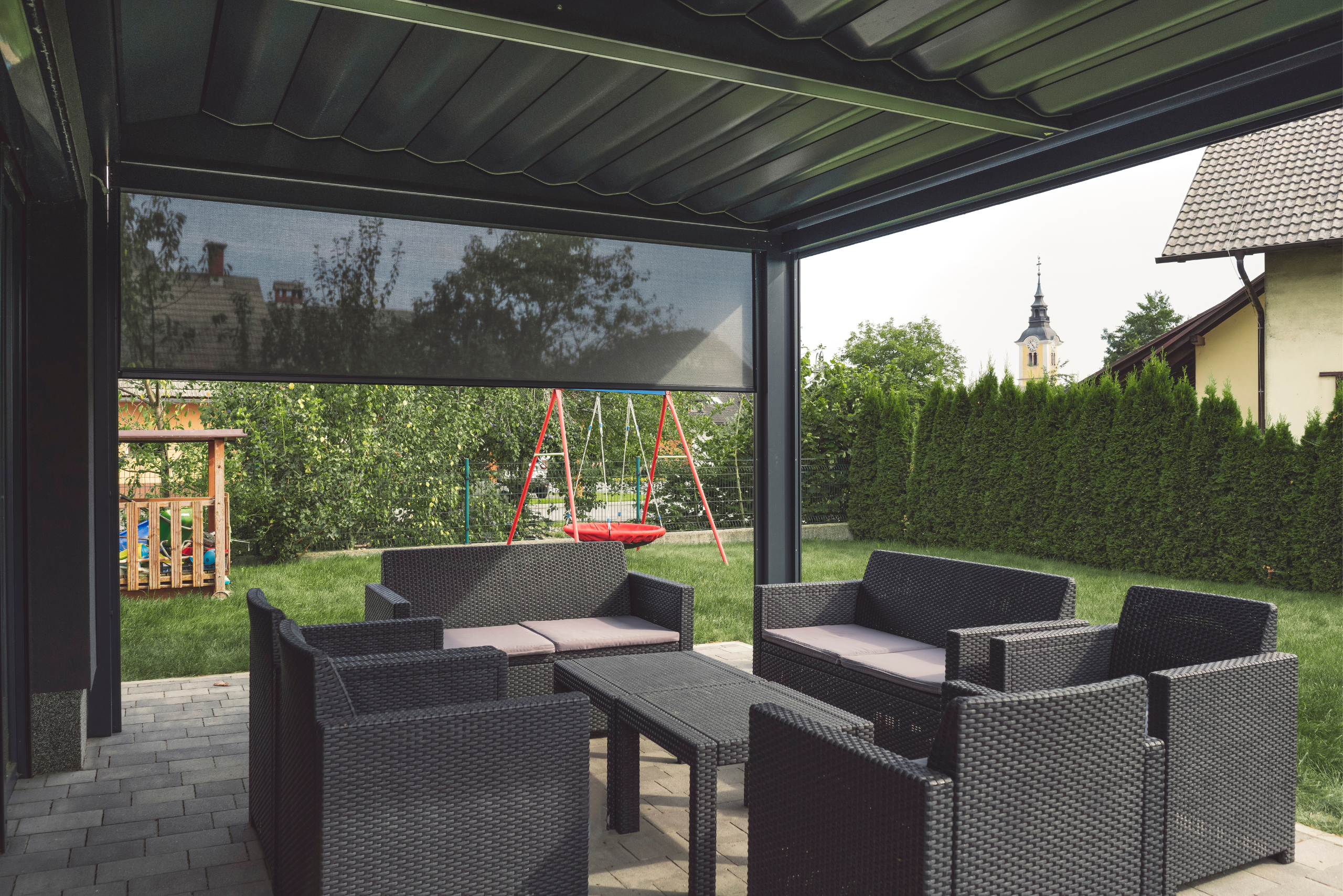 Grey outdoor furniture under a pergola.