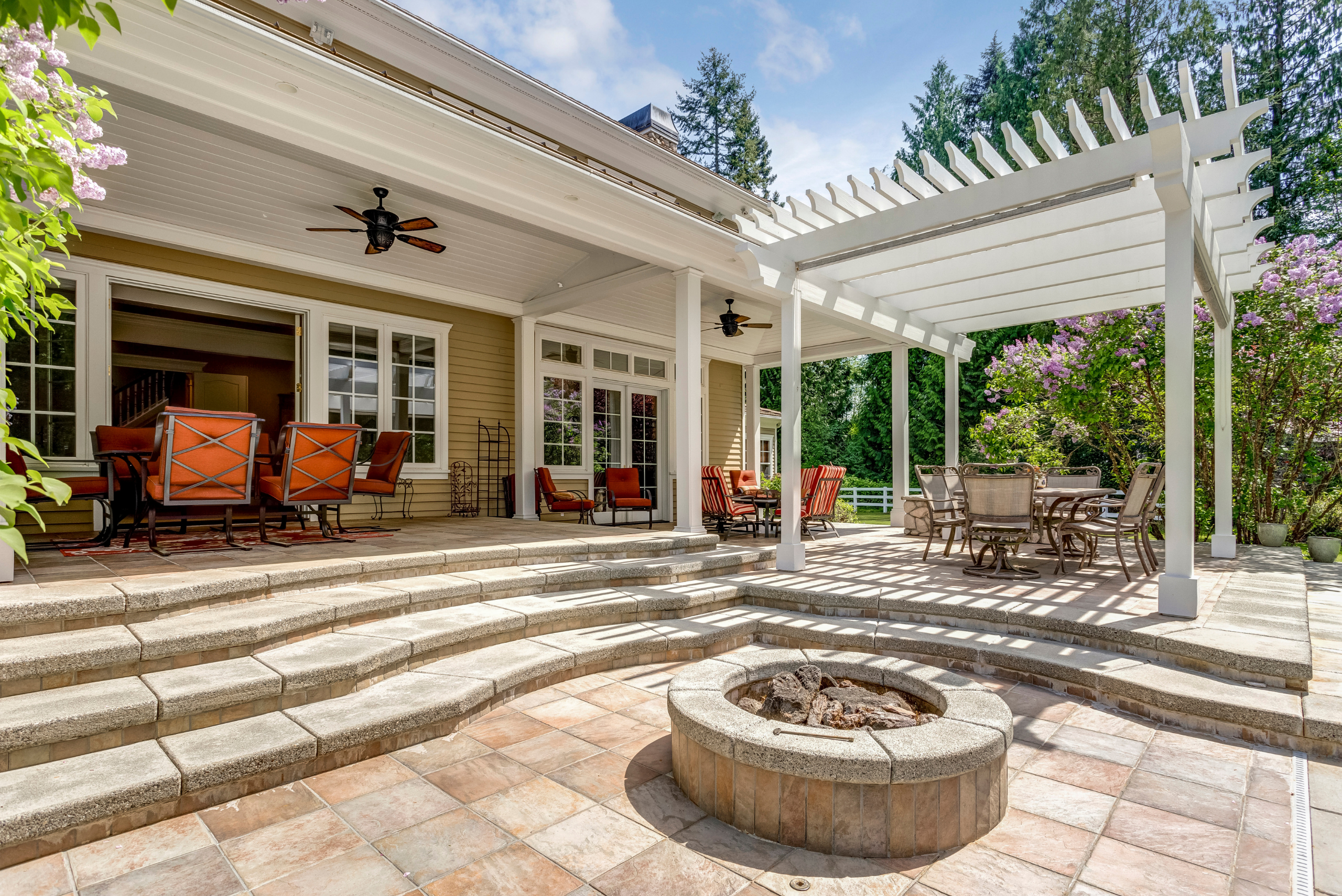 White pergola over patio furniture.