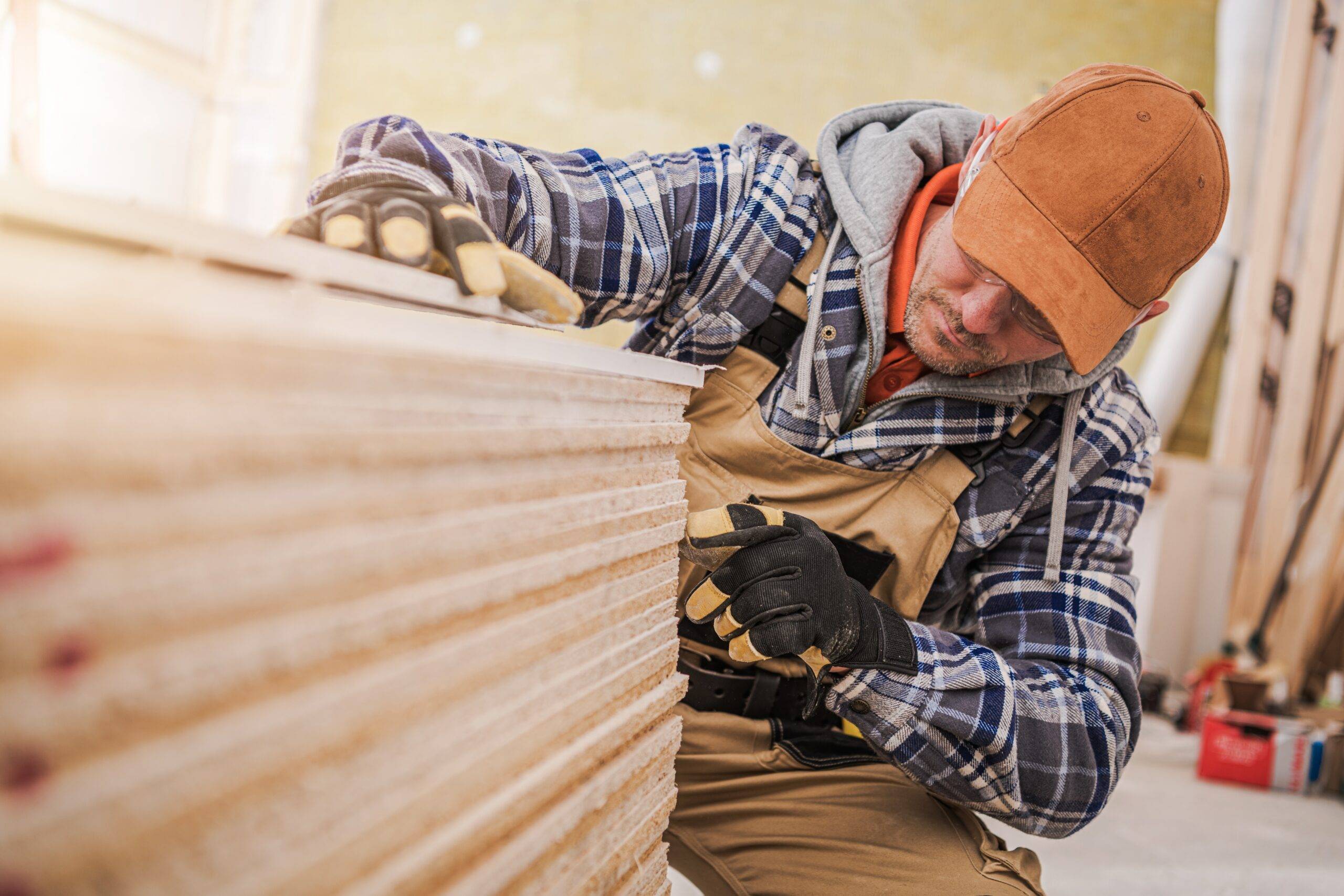 Pile of Plywood boards being counted by construction worker.